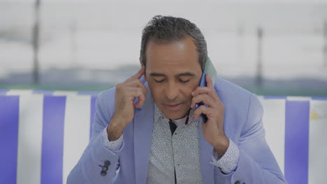 hombre molesto hablando por teléfono celular al aire libre