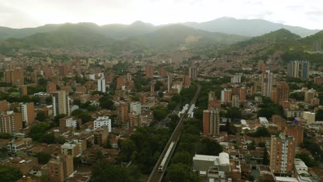 Wunderschöner-Drohnenblick-Auf-Den-U-Bahn-Zug-In-Der-Malerischen-Kolumbianischen-Stadt-Medellin