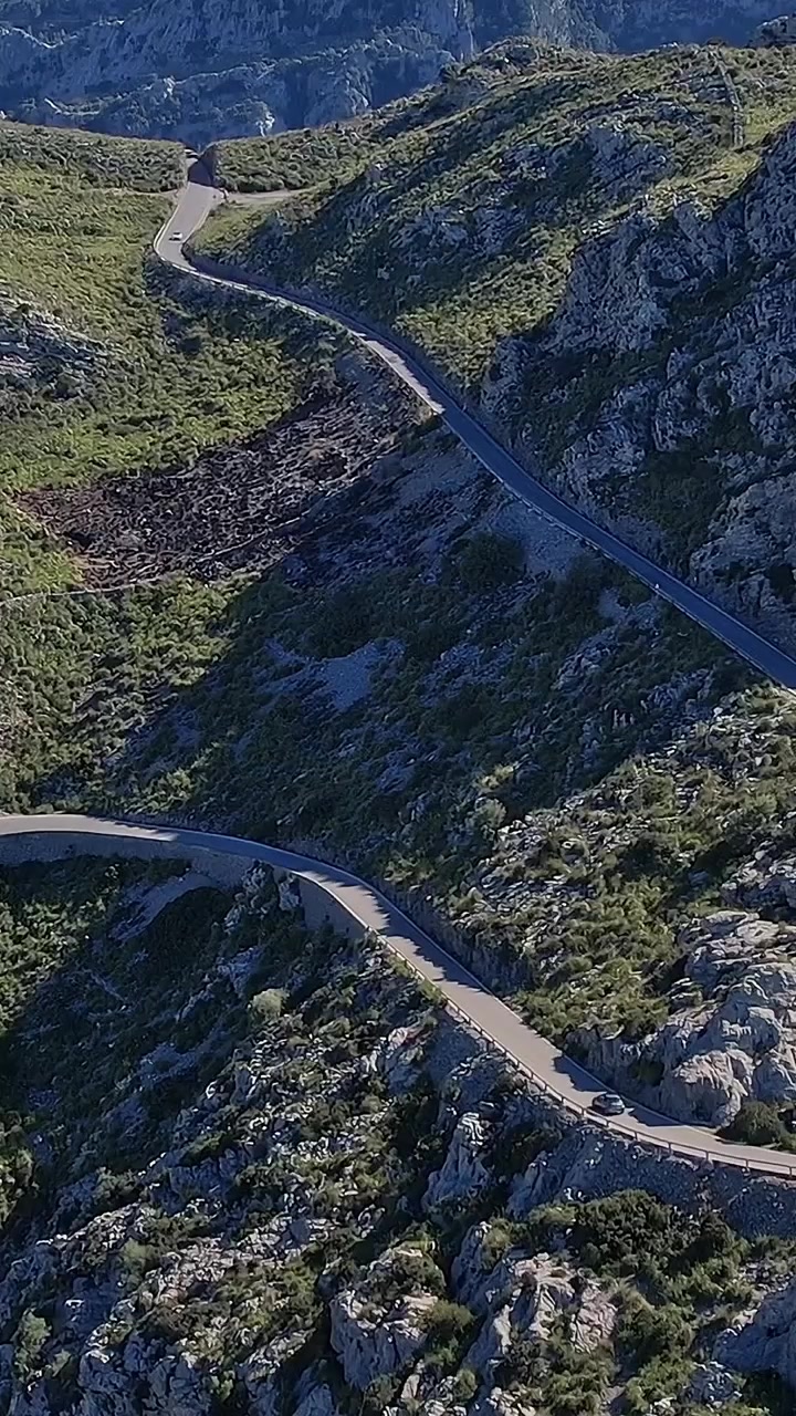 Carretera sinuosa a través de terreno rocoso en VertMall, España, capturada desde arriba