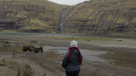 ancho de una mujer mirando hacia un valle en las islas feroe