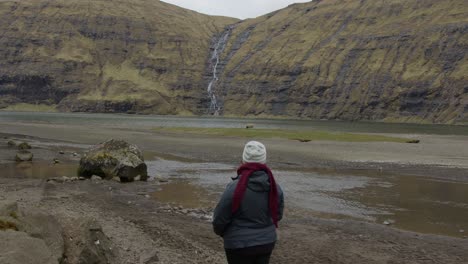 wide of a woman staring out into a valley in the faroe islands