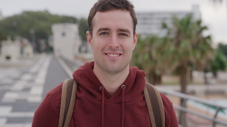 ritratto giovane affascinante che ride godendo di una vacanza di successo stile di vita indipendente studente maschio viaggio estivo in città urbana sullo sfondo sul mare rallentamento
