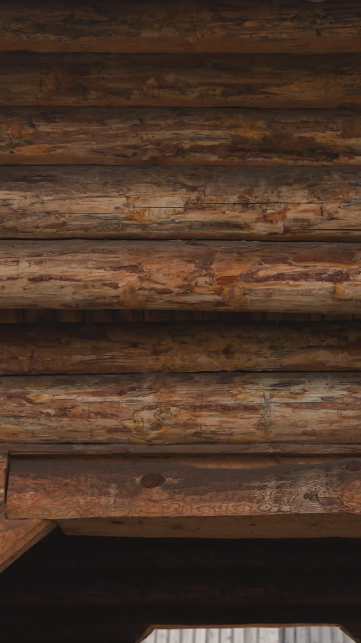 un hombre barbudo con ropa de caballero camina a través del patio más allá de la puerta de madera del castillo medieval. un joven guerrero camina más allá de una tienda blanca patrullando el territorio cuidadosamente.