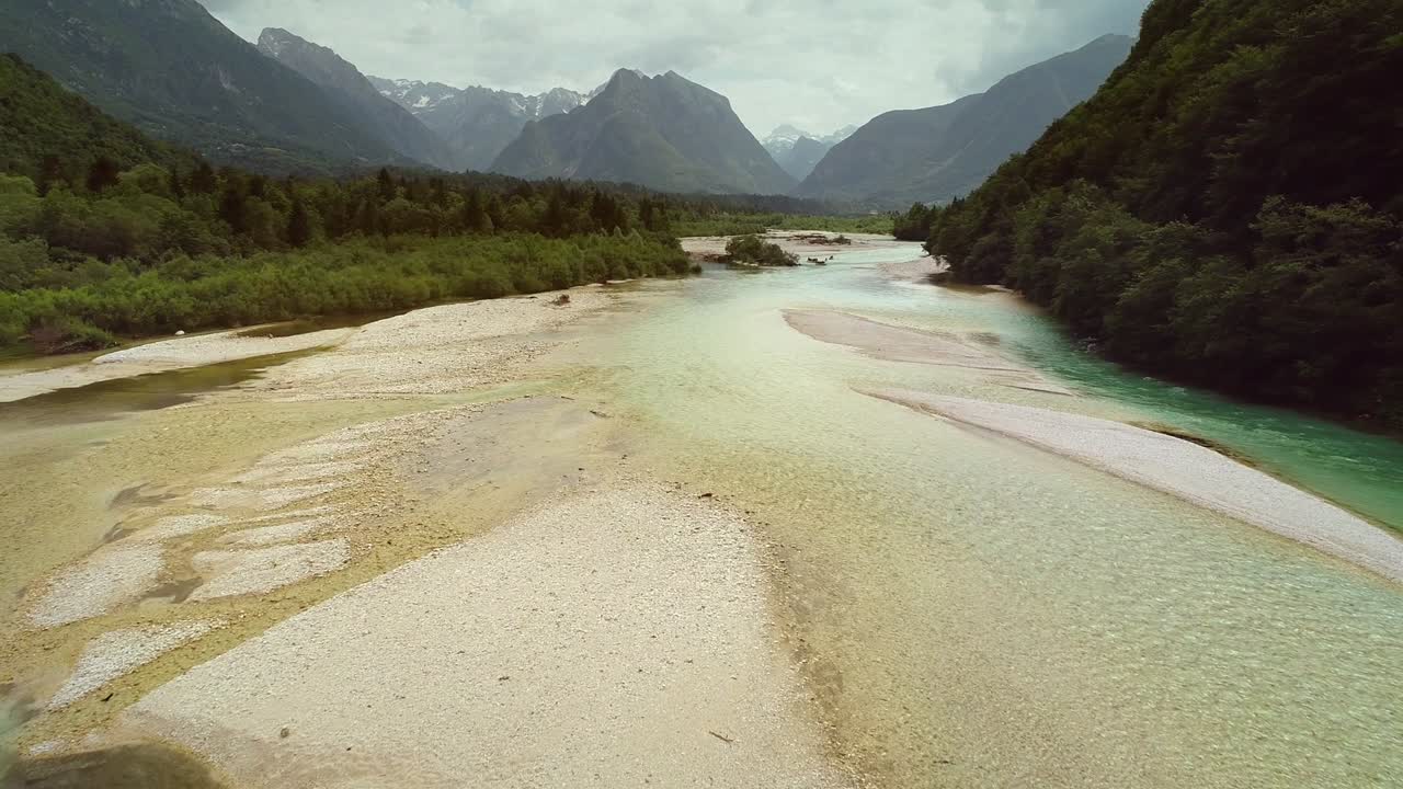 슬로베니아의 많은 언덕과 식물로 둘러싸인 소카 강의 공중 풍경.