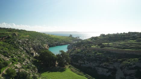 AERIAL:-Magrr-Ix-Xini-Bay-with-Beautiful-Clear-Colourful-Water-Reflecting-Sun