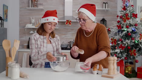 la nieta pone el ingrediente de la harina en el tamiz mientras la nieta tamiza