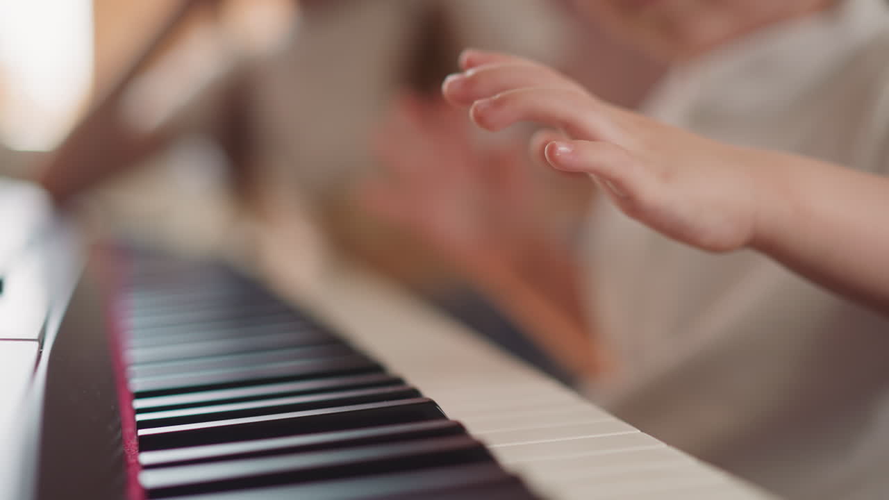 los dedos gordos del niño presionan las teclas del piano aprendiendo composición