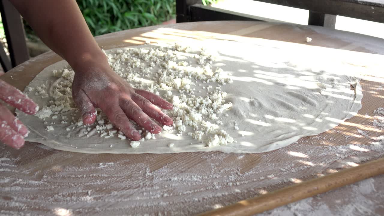 터키 플래트브레드. 가까운 요리사는 채우기와 함께 맛있는 케이크를 준비합니다.