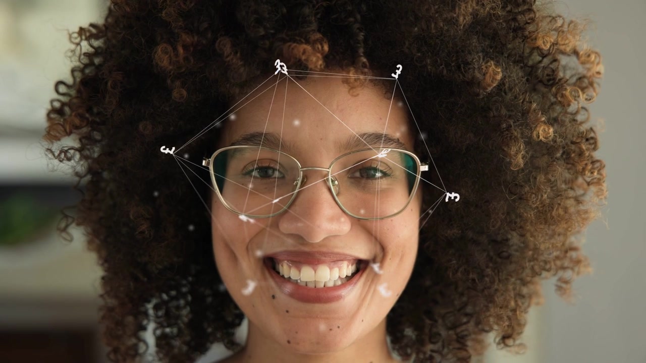 Woman facing camera, smiling and laughing as face mesh overlay appears over glasses showcasing tech