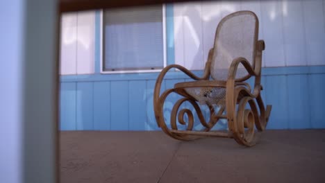 grandma's old wooden rocking chair on porch of secluded forest cabin in slow motion