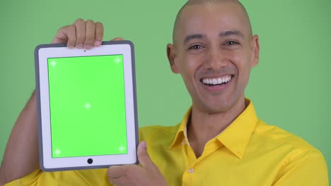 feliz hombre de negocios calvo y guapo mostrando una tableta digital