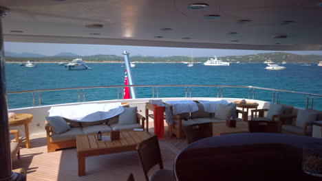 panning view to left from the deck of a luxury yacht parked at sea outside of saint tropez, cannes, south of france, many yachts in the sea