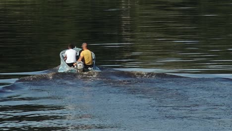 a group of fishermen is floating on a river in a motorboat, surrounded by calm waters and natural scenery. the scene reflects a peaceful outdoor activity. copy space available.