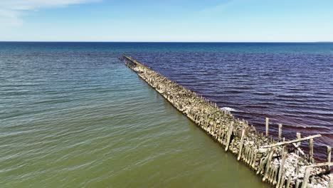 The-remains-of-the-old-stone-and-wooden-pile-bridge,-which-was-built-in-the-Baltic-Sea,-on-the-beach-of-the-town-of-Sventoji