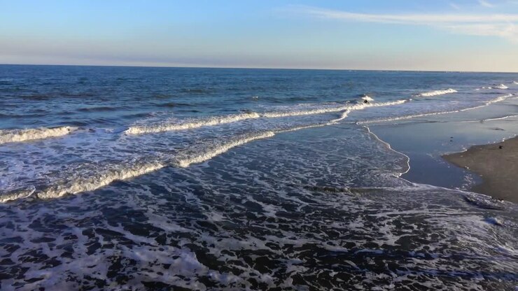 Onde che si infrangono sulla Spiaggia di Tybee Island durante la sera