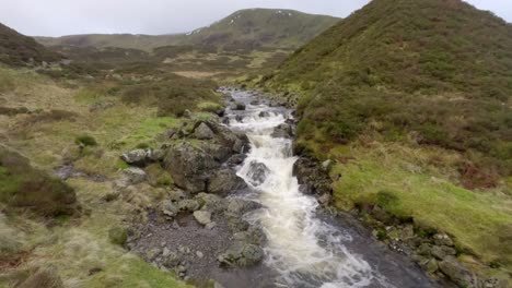 A-small-river-flows-quickly-down-after-heavy-rainfall,-alongside-the-path-for-Gray-Mare's-Trail