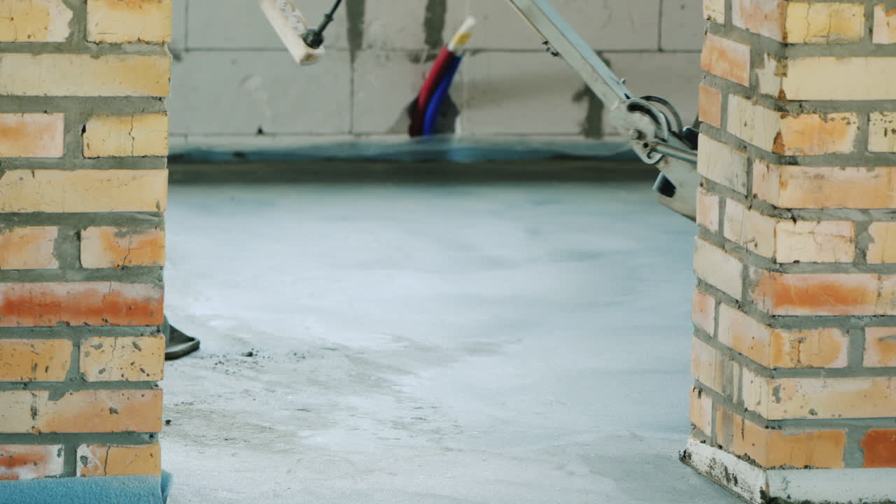 전동 공구를 사용하는 작업자가 바닥의 콘크리트 스티치를 덮을 것입니다.