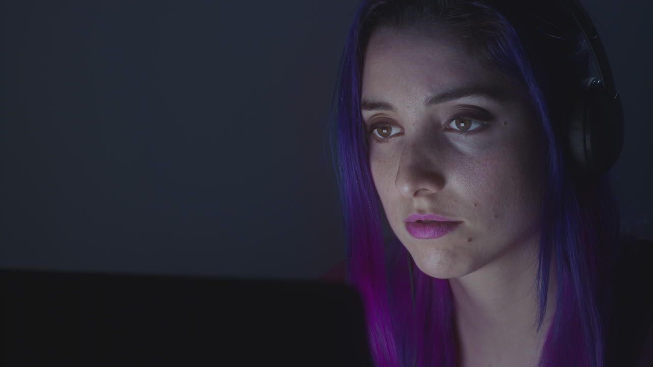 cerca de una mujer joven buscando en su computadora portátil y escuchando música.