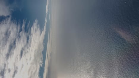 Vista-Aérea-Del-Cielo-Azul-Y-El-Mar,-Tiro-Vertical