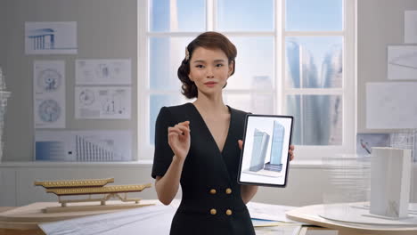 architectural presentation: woman showcasing 3d building models on tablet