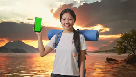 woman with backpack and phone at sunset