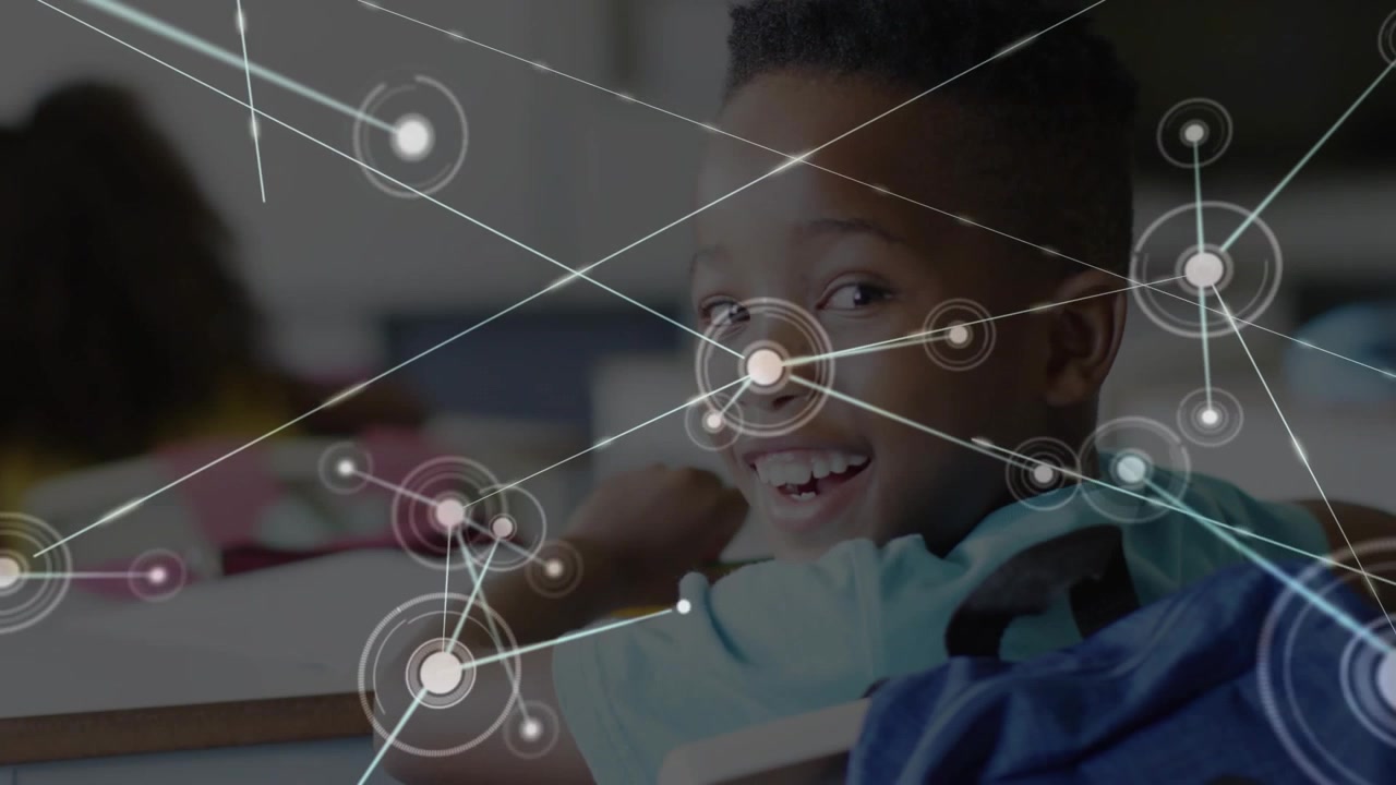 Boy turning head smiling in classroom causing circular graphic around him spawning rays and nodes