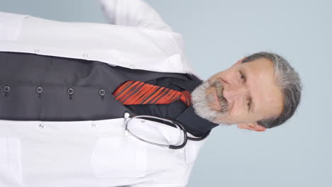 video vertical del viejo médico haciendo corazón mirando a la cámara.