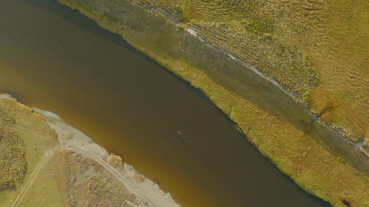 hermosa toma aérea de un dron mirando a un pescador echando agua en un río en argentina