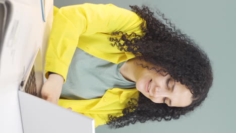 Vertical-video-of-Young-woman-looking-at-laptop-is-happy-and-dancing.