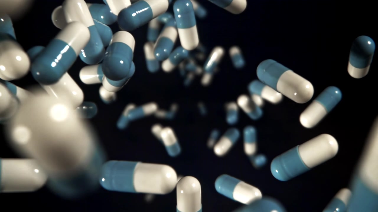 Capsule mediche blu e bianche che cadono al rallentatore