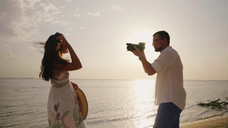 Der-Mann-Fotografiert-Seine-Junge-Frau-Am-Strand-Schöne-Feiertage-Zusammen-4k-Video