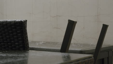 autumn rain pouring on the balcony with furniture