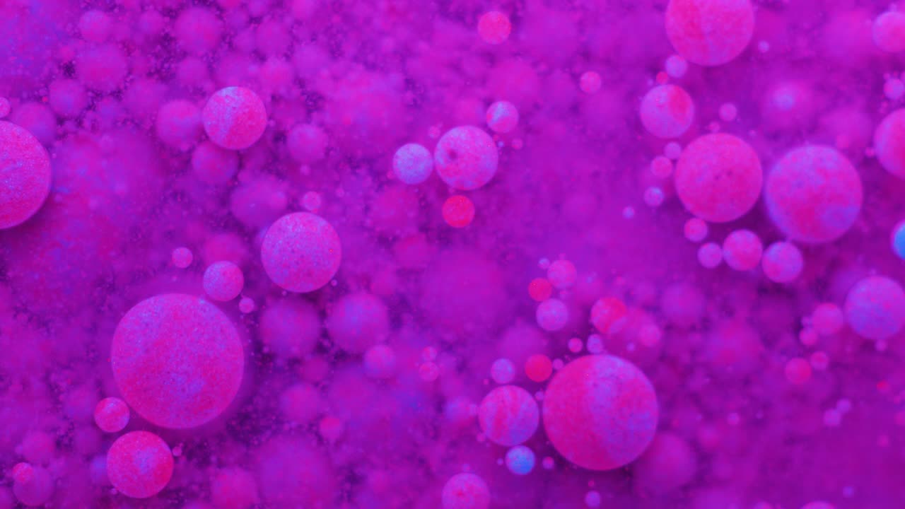 Slow Motion Bright Neon Color Bubbles Oil Beautiful Fluorescent Paint Sparkling Color Moving Multicolor Close up. Acrylic Neon Paint. Fantastic Surface. Abstract Colorful Transformation Gravitation.