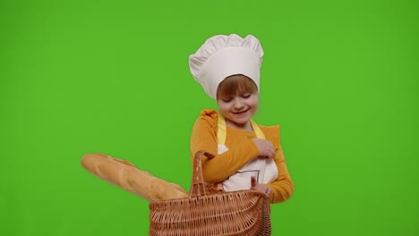 Child-girl-chef-cook-showing-basket-with-baguette-and-bread,-smiling,-sniffing-on-chroma-key