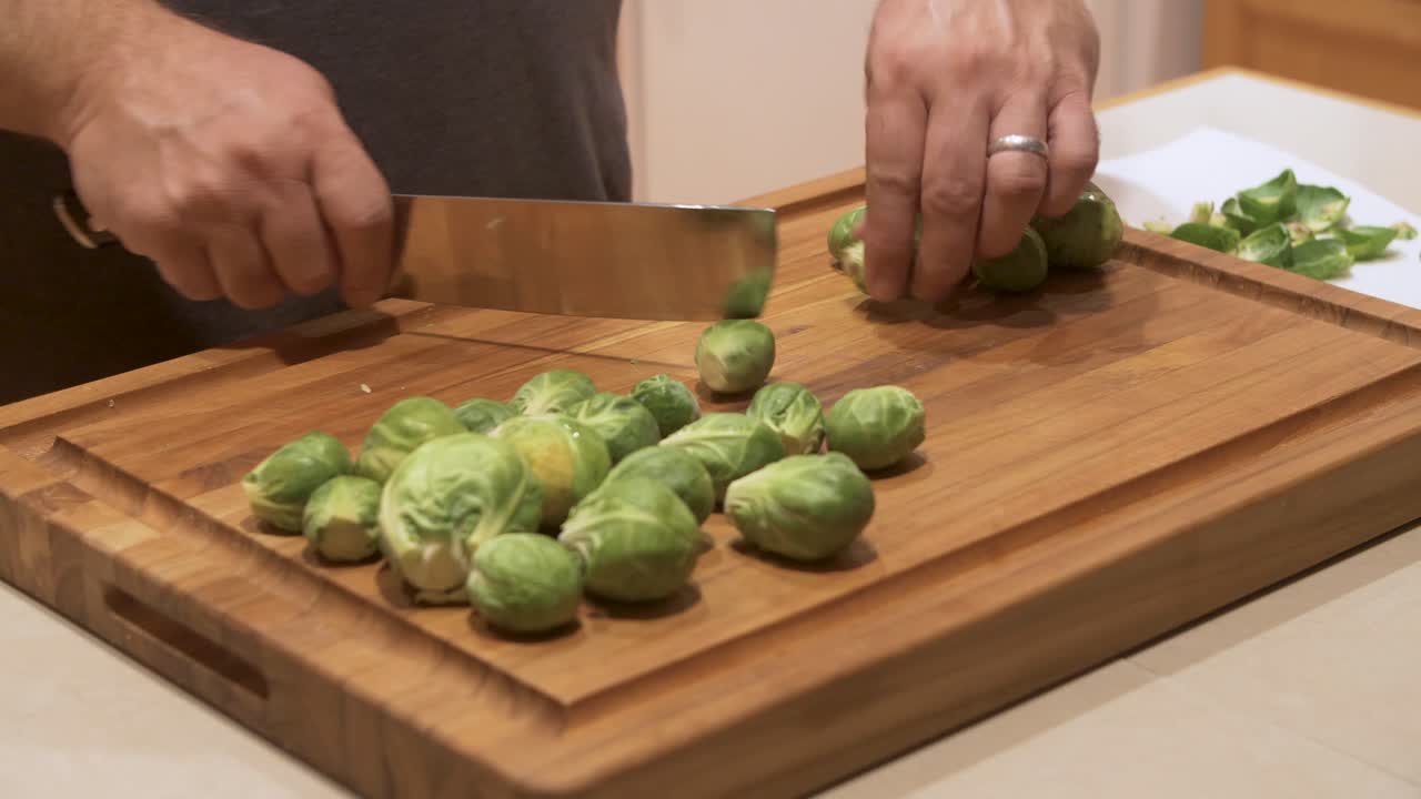 Preparing raw brussel sprouts for dinner, trimming the ends off whole brussel sprouts