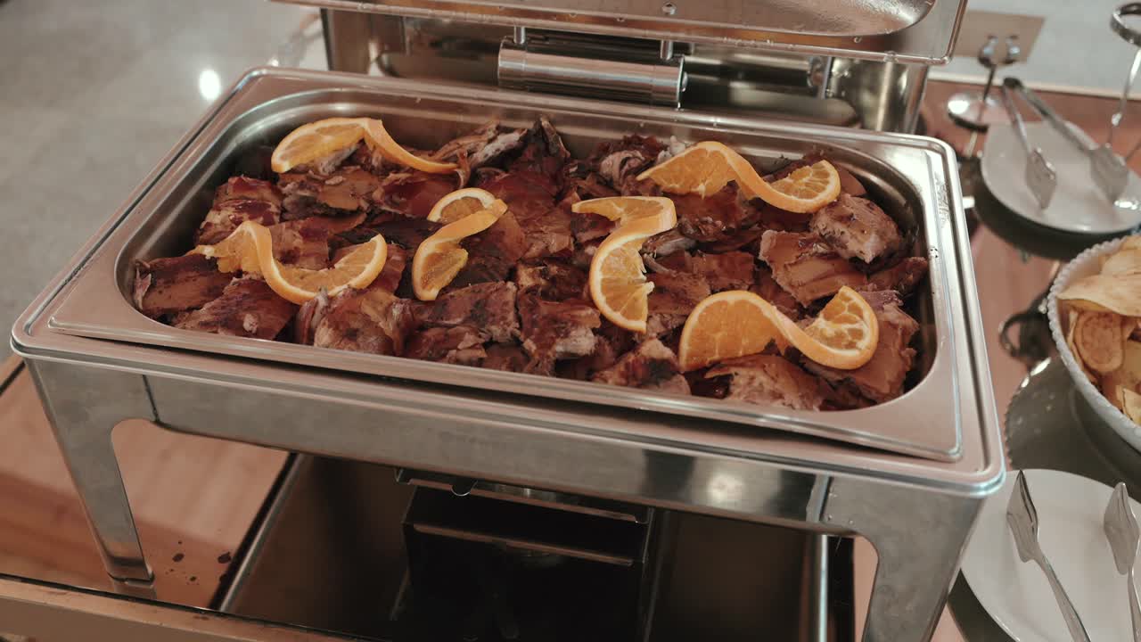 Tender roasted meat with orange garnish shines on buffet table