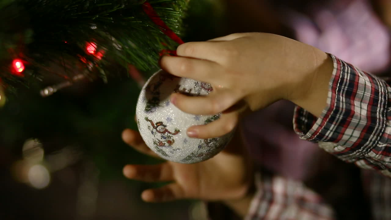 Family Decorating Christmas Tree. Happy family decorating a Christmas tree with boubles in the living-room