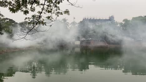 fog from insecticide spray floating over park pond in dhaka