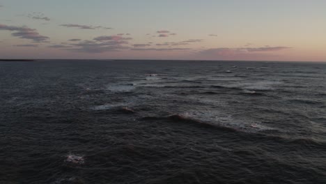 peaceful dusk last light over whitecaps as waves break on ocean and mist rises, chincoteague island virginia, slow motion