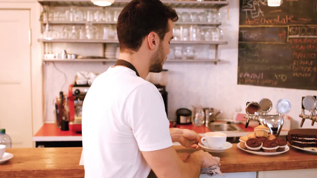 el camarero limpiando el mostrador.