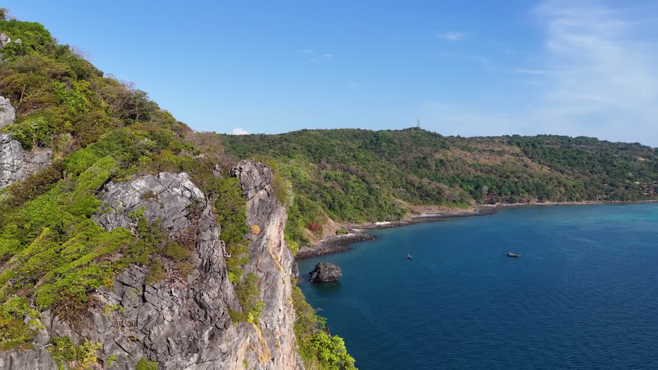 Cảnh quay từ drone ghi lại những vách đá vôi dựng đứng và làn nước màu ngọc lam dưới bầu trời xanh trong vắt.