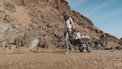 woman going with cart in post apocalyptic desert