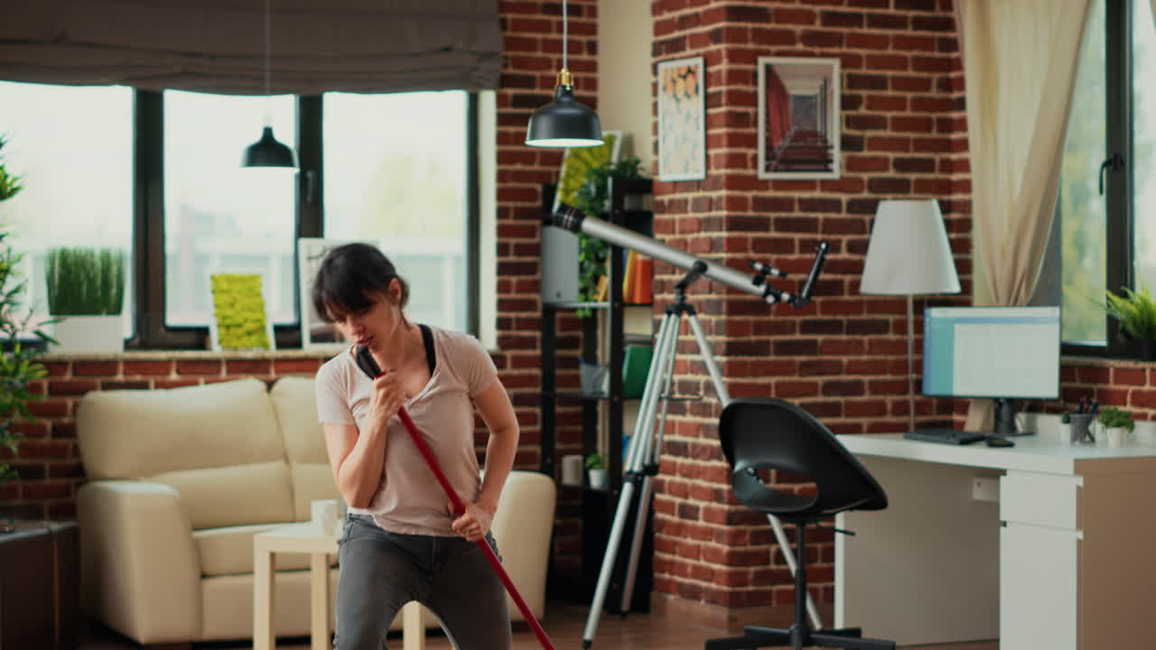 Caucasian woman acting silly mopping wooden floors