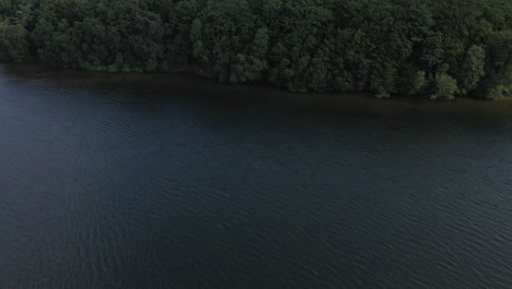 Luftdrohne-Aufsteigend-Pov-über-Trémelin-über-See-Und-Grünem-Wald,-Bretagne-In-Frankreich