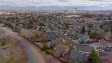 slow pull away from subdivision in reno, nevada with city skyline and mountains on the horizon on a pretty winter day
