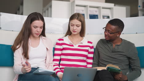 three students working together in a library