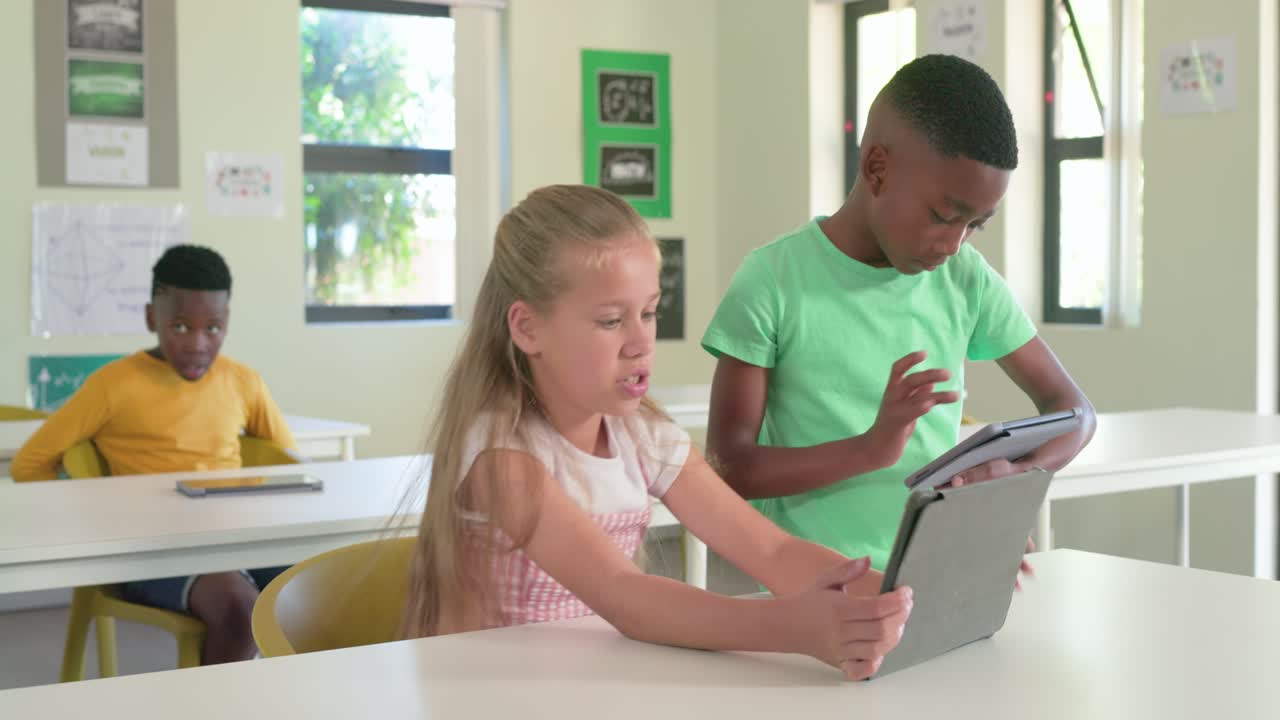 Diverse students comparing tablets with boy approaching, girl angling gray case, rear youth tapping