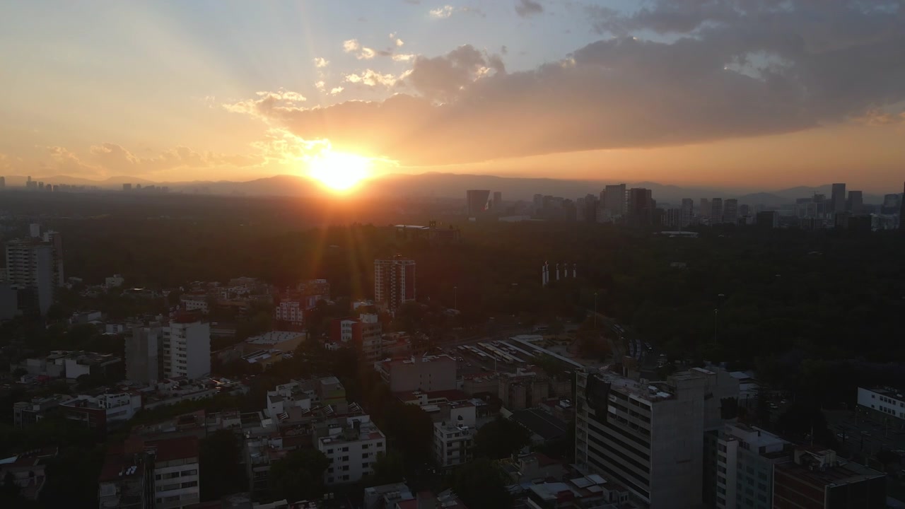 Panorama aéreo cinematográfico da paisagem urbana da Cidade do México, telhados de edifícios de apartamentos com pôr do sol no horizonte. Conceito de arquitetura urbana de imóveis