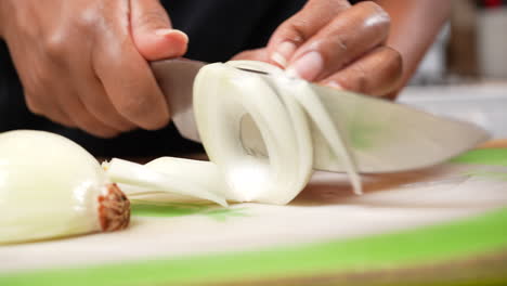 slicing an organic onion to dice for a homemade recipe - side view isolated