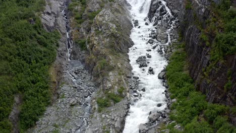 vista aérea del agua del arroyo rápido cayendo por las colinas rocosas de alaska